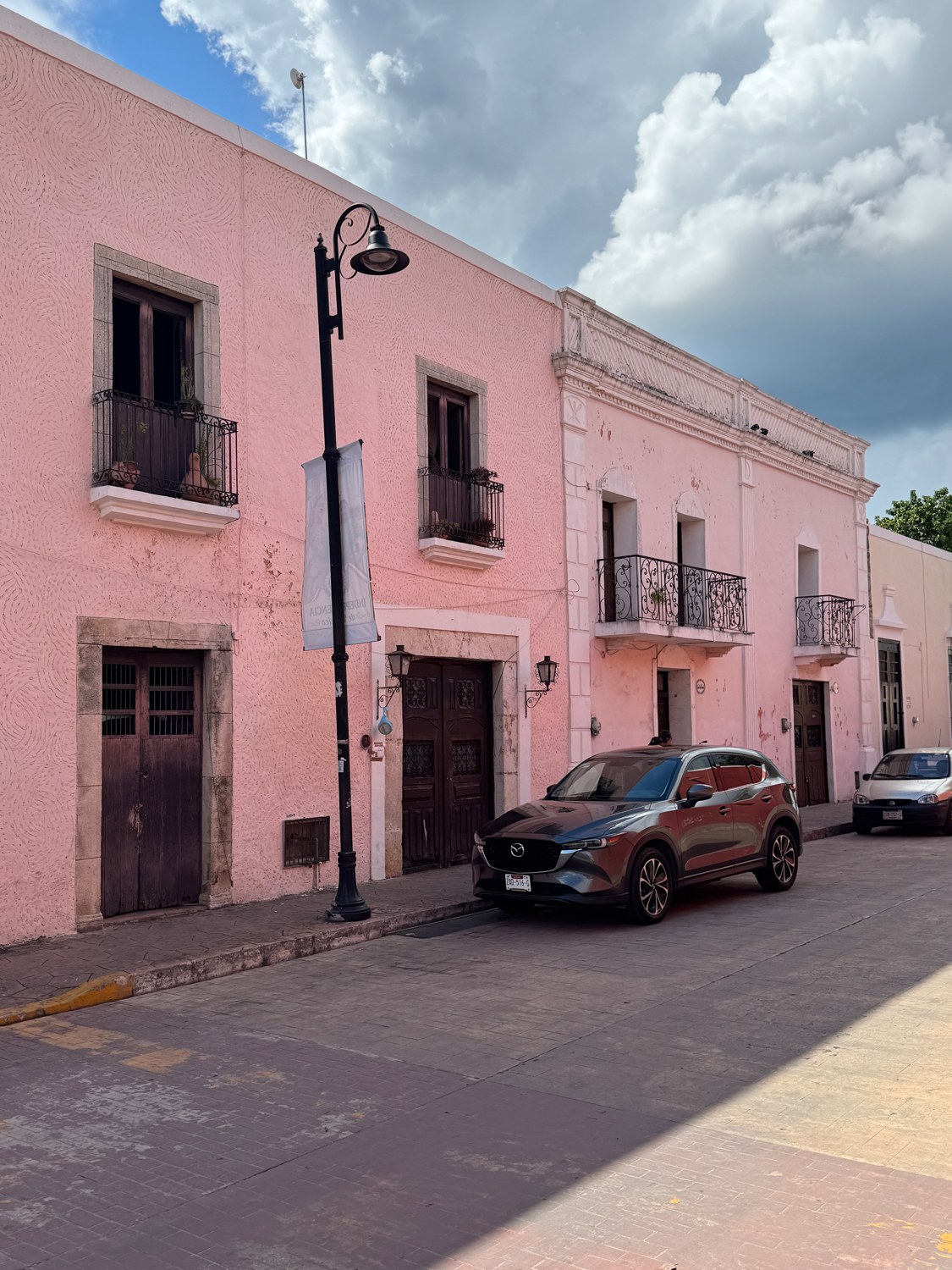 Rosa Fassade mit Laterne und Autos in Valladolid