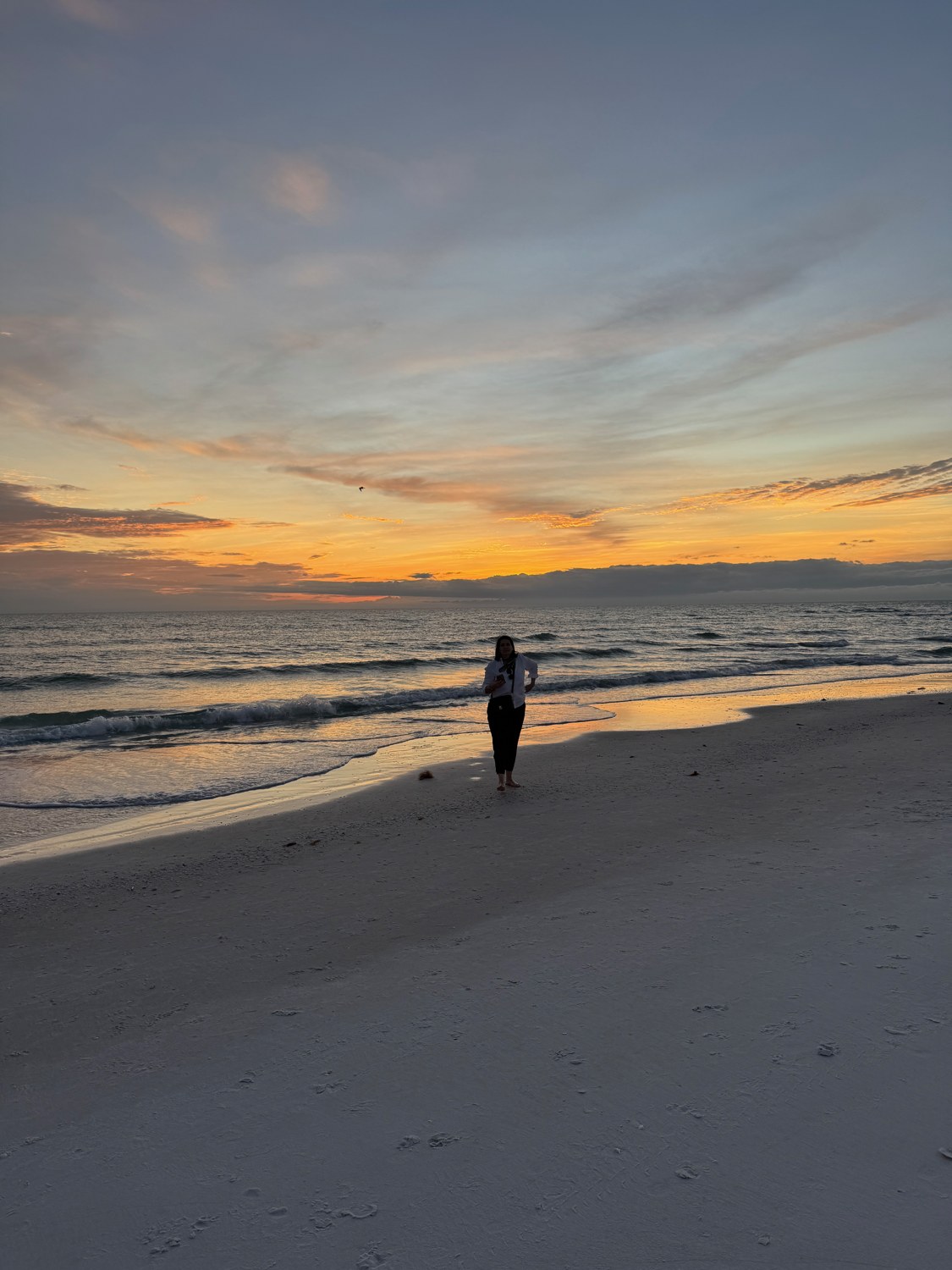 Strand bei Abendlicht in Sarasota mit kleiner Person am Wasser